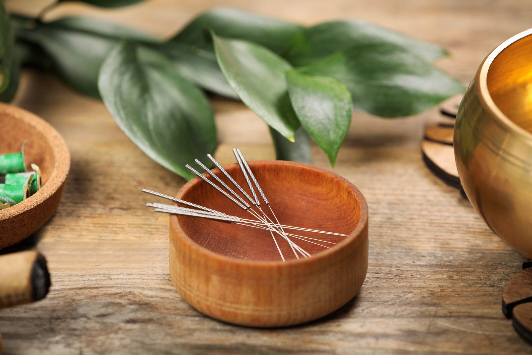 Acupuncture needles in a wooden bowl.