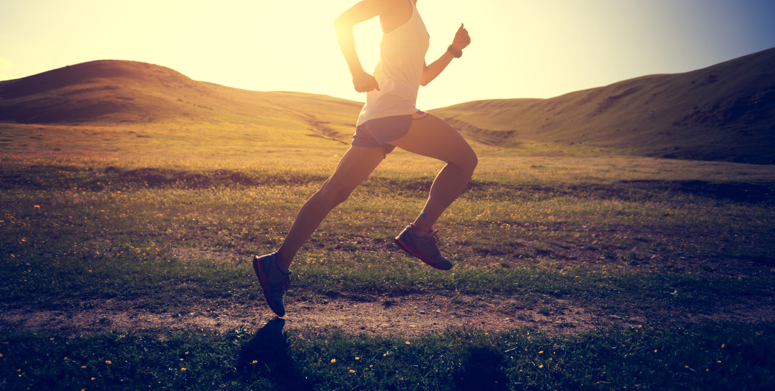 young fitness woman runner running on sunset trail